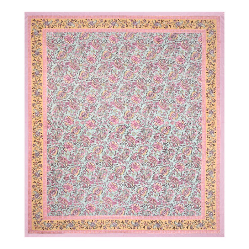 May include: A large, rectangular textile with a repeating paisley pattern in pink, yellow, and green on a light blue background. The border is a light pink with a yellow floral design. This textile is suitable for a bedspread or tablecloth.