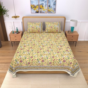 Può includere: Un set di lenzuola giallo caratterizzato da un fitto motivo floreale multicolore con disegni botanici rossi, rosa, blu e verdi. Il set include due federe rettangolari abbinate e un grande copriletto con una bordatura decorativa.