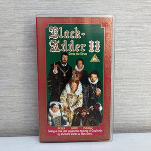 May include: A VHS tape of "Blackadder II: Parte the Firste" featuring a cast in period costumes. The cover is green with gold lettering and a red border. The PG rating is visible.