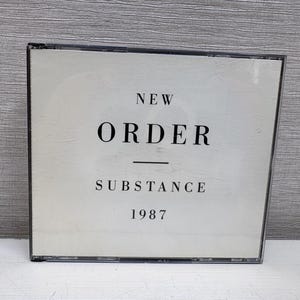 Puede incluir: Una caja de CD cuadrada con una portada blanca y texto negro que dice NEW ORDER, centrado debajo está ORDER, seguido de una línea horizontal, luego SUBSTANCE y finalmente el año 1987 en la parte inferior de la portada del álbum.