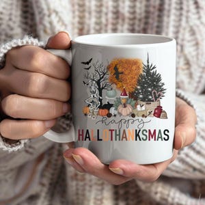 May include: White ceramic mug featuring a festive "Hallothanksmas" design. The design includes a skeleton, pumpkins, a Christmas tree, and the word "happy". The mug is held by a person wearing a cream-colored sweater.