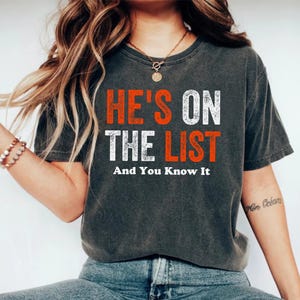 Er ist auf der Liste und Sie wissen, dass es Shirt Lustiges sarkastisches Politisches T-Shirt, Verschwörungsstimmung Shirt, Satire Grafik T-Shirt, mutiges Statement Geschenk T-Shirt