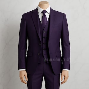 Puede incluir: Un traje morado de tres piezas exhibido en un maniquí. El conjunto incluye una americana, un chaleco y un pantalón. Una camisa blanca y una corbata morada completan el conjunto. El traje es de corte clásico, ideal para eventos formales.