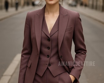 May include: A three-piece mauve suit, including a blazer, vest, and trousers. The suit features a tailored fit with a notched lapel on the blazer and a button-down vest. The text "AMANIQUEATTIRE" is visible on the lower right. The outfit is suitable for business or formal occasions.