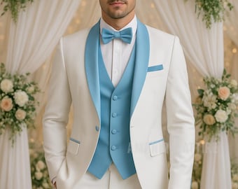 May include: A formal white suit with light blue accents. The suit includes a jacket with a shawl collar, a vest, and a bow tie. The background features floral arrangements and soft lighting, creating an elegant atmosphere.