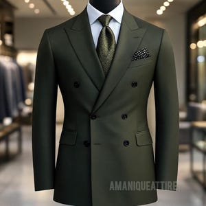 Op de afbeelding: Een donkergroen dubbelknoops pak op een mannequin. Het pak heeft een wit overhemd, een stropdas met patroon en een pochet. De tekst "AMANIQUEATTIRE" is zichtbaar. Het pak wordt gepresenteerd in een goed verlichte winkelomgeving.
