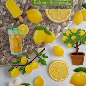 Könnte beinhalten: Ein Bogen mit Aufklebern zum Thema Zitrone mit verschiedenen Designs, darunter ganze Zitronen, Zitronenscheiben, ein Zitronenbaum und ein Glas Limonade. Die Aufkleber enthalten auch ein Eis am Stiel, Blumen und den Text "Rub on - Rubbelsticker".