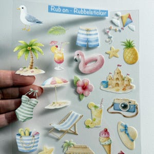 Könnte beinhalten: Ein transparenter Bogen mit Rubbelstickern zum Thema Strand, darunter eine Möwe, eine Palme, ein Flamingo-Schwimmring, eine Sandburg, ein Leuchtturm, Eis, Cocktails, Badekleidung, ein Liegestuhl und der Text Rub on - Rubbelsticker.