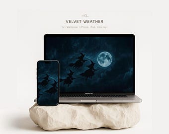 May include: A laptop and smartphone display a dark blue wallpaper featuring silhouetted witches flying across a full moon. The devices rest on a beige, textured stone. The text "The VELVET WEATHER" is above the set wallpaper information.