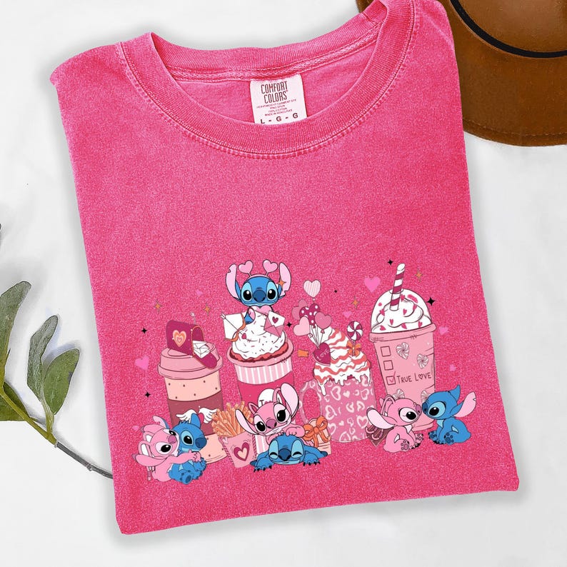 May include: A pink Comfort Colors t-shirt featuring a graphic of Stitch characters with Valentine's Day themed desserts and the words "True Love". The design includes hearts and a variety of treats.
