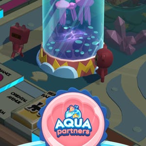 May include: A digital game interface featuring a cylindrical aquarium with pink jellyfish, a red die on top, and two small brown figures. A circular pink badge with a scalloped blue border displays the text Aqua partners with a fish icon.