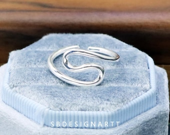 Anillo de alambre de plata de ley 925 con diseño geométrico minimalista de curva irregular y ondas playeras.