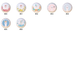 May include: Set of six round ceramic ornaments featuring various llama designs. Each ornament has a white background with a colorful llama illustration and floral accents. The ornaments are numbered 29 through 38.