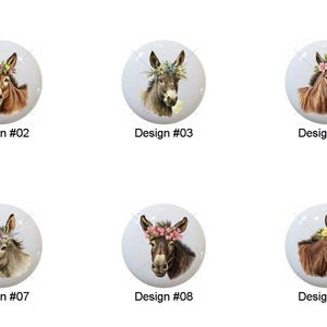 May include: A collection of ten white ceramic cabinet knobs, each featuring a detailed illustration of a donkey wearing a floral crown. The donkey's fur varies in shades of brown, gray, and tan. Each knob is labeled with a design number.
