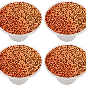 May include: Four ceramic knobs with a leopard print design. The knobs are orange and brown with a white base.