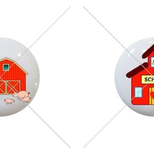 May include: Two ceramic knobs with red and white designs. One knob features a red barn with a silo and three pink pigs. The other knob features a red schoolhouse with a yellow sign that says "SCHOOL".