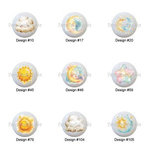 May include: A collection of decorative cabinet knobs with celestial designs. Each knob features a different design, including stars, moons, clouds, and suns, with watercolor-style illustrations. Each knob is labeled with a design number.