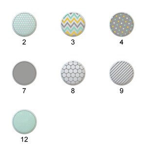 May include: A collection of twelve round decorative elements with various patterns and colors. Designs include solid colors, geometric patterns like chevrons and stripes, and dotted patterns. Each element has a stitched border.