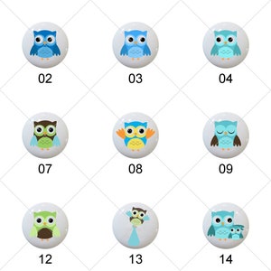 May include: A set of fifteen round white ceramic knobs, each featuring a unique colorful owl illustration. The designs include various shades of blue, green, brown, and yellow, with each knob labeled with a black number from 01 to 15 below it.