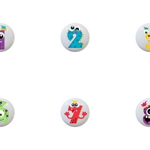 May include: Set of ten colorful ceramic knobs featuring cartoon monster characters with numbers 0 through 9. Each knob has a different color and design.
