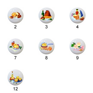 May include: Twelve white ceramic knobs with colorful illustrations of different food items, such as bread, wine, cheese, and pastries. Each knob is numbered 1 through 12.
