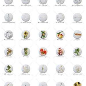 May include: Thirty white ceramic ornaments with various fall-themed illustrations, including wreaths, acorns, sunflowers, corn, and wheat. Each ornament is numbered with a corresponding description.