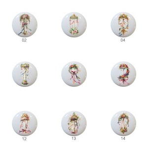 May include: A set of 14 floral themed ceramic knobs with a white background. Each knob features a different arrangement of flowers, ribbons, and a pedestal. The knobs are numbered 01 through 14.