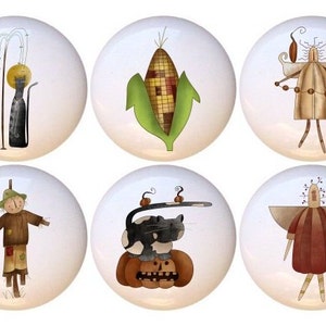 May include: Set of 10 ceramic knobs featuring whimsical fall-themed illustrations. Designs include a scarecrow, a cat, a corn cob, a jug, a pumpkin, and more.
