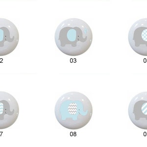 May include: Ten ceramic knobs with different blue and gray elephant designs. The knobs are round and have a white background.
