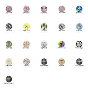 May include: A collection of 16 round, colorful, decorative ceramic tiles featuring dragonfly designs. The tiles are arranged in a grid pattern. Some tiles have a white background with a dragonfly in the center, while others have a dragonfly on a colored background. The tiles are all approximately 2 inches in diameter.