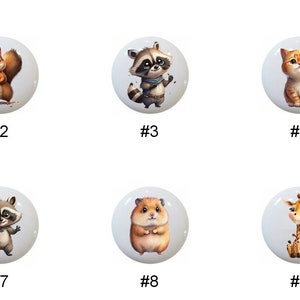 May include: Nine ceramic knobs with different animal designs. The knobs are white with a glossy finish. The animals include a zebra, squirrel, raccoon, cat, hamster, giraffe, and two more raccoons. The knobs are numbered 1 through 9.