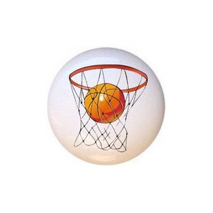 May include: A basketball going through a hoop with a net. The basketball is orange and brown with black stitching. The hoop is orange and the net is black.