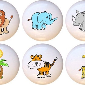 May include: Set of six ceramic knobs featuring cartoon animal illustrations. The knobs are white with colorful animal designs, including a lion, elephant, rhinoceros, tiger, giraffe, and a palm tree with a sun.
