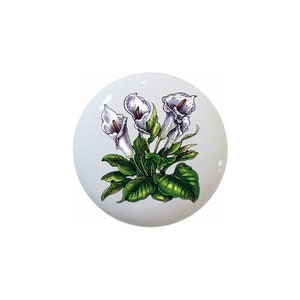 May include: White Calla Lilies with green leaves on a white background. The flowers are arranged in a bouquet.