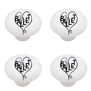 May include: Four white ceramic cabinet knobs with a black design of a heart with the word "Ballet" inside.