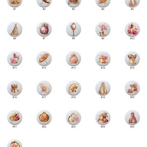May include: Twenty-six round ceramic knobs with various vintage-inspired designs, including floral patterns, hats, purses, and a corset. Each knob is white with a gold rim and features a different design.