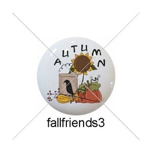 May include: Five round ceramic ornaments with fall-themed designs. The ornaments feature a turkey, a bird on a sunflower, a bird in a birdhouse, a witch, and a sheep.