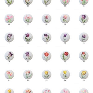 May include: Thirty assorted ceramic tiles featuring hand-painted tulip designs in various colors, including red, pink, yellow, purple, and orange. Each tile is approximately 2 inches in diameter.