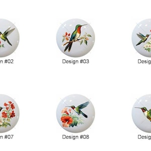 May include: A collection of ten white ceramic cabinet knobs, each featuring a unique hummingbird design with floral accents. The knobs are labeled with the design numbers #01 through #10.
