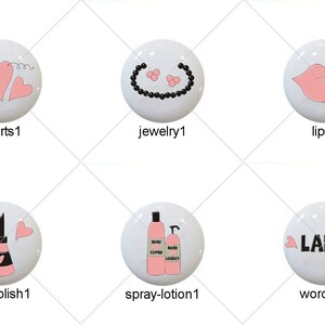 May include: Set of ten white round buttons with pink and black designs. The designs include a hairbrush, hearts, jewelry, lips, lipstick, makeup, nail polish, spray bottle, and the word "LADY".