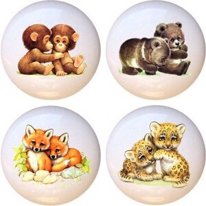 May include: Set of eight ceramic knobs featuring pairs of cute animals, including bears, monkeys, pandas, foxes, leopards, and tigers. Each knob is white with a colorful animal illustration.