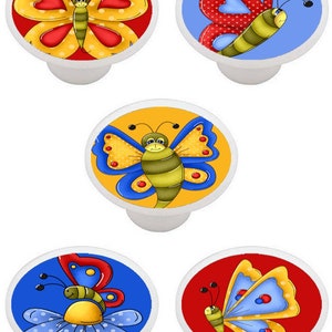 May include: Set of five ceramic drawer knobs featuring colorful butterfly designs. Each knob has a different butterfly with yellow, red, blue, and green accents.