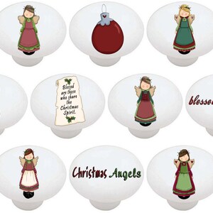 May include: Set of 10 white ceramic Christmas themed cabinet knobs. The knobs feature images of angels, ornaments, and text that says "blessed christmas" and "Christmas Angels".