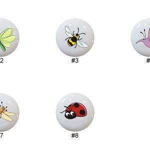 May include: Eight ceramic knobs with different insect and butterfly designs. The knobs are white with colorful illustrations of a ladybug, dragonfly, bee, butterfly, grasshopper, beetle, and two other butterflies.