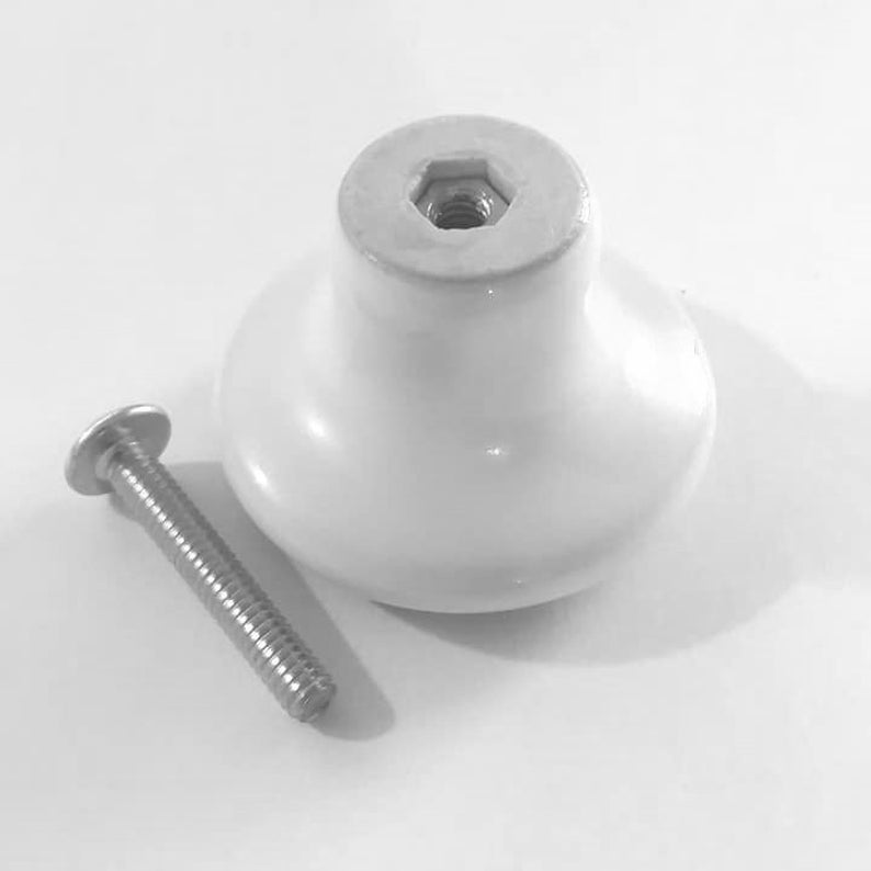Peut inclure: Bouton de porte en c&eacute;ramique blanche avec une base ronde et une vis pour l'installation.