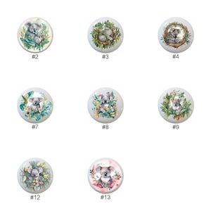 May include: Thirteen ceramic knobs with watercolor illustrations of koalas in various poses, surrounded by greenery and flowers. The knobs are white with a glossy finish.