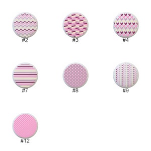 May include: Twelve different patterns of pink, white, and purple fabric swatches. The swatches are circular and feature various geometric designs, including polka dots, stripes, hearts, and zigzags.