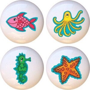 May include: Four ceramic knobs with colorful sea creature designs. The knobs feature a pink fish, a yellow octopus, a green seahorse, and an orange starfish.