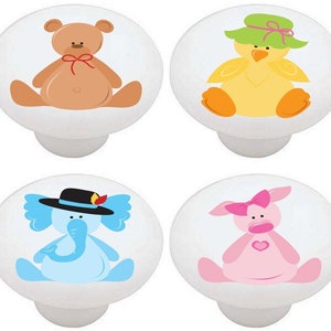 May include: Set of four ceramic knobs featuring a teddy bear, a chick wearing a green hat, a blue elephant wearing a black hat, and a pink pig wearing a pink bow. Each knob is white with a colorful cartoon animal design.