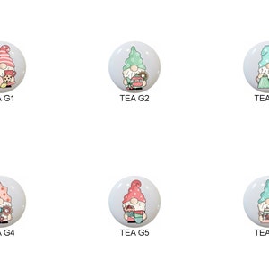 May include: Six round ceramic ornaments featuring gnomes holding teacups, teapots, and other tea-related items. The gnomes are wearing pink, green, and blue hats with white polka dots. The ornaments are labeled "TEA G1" through "TEA G6".